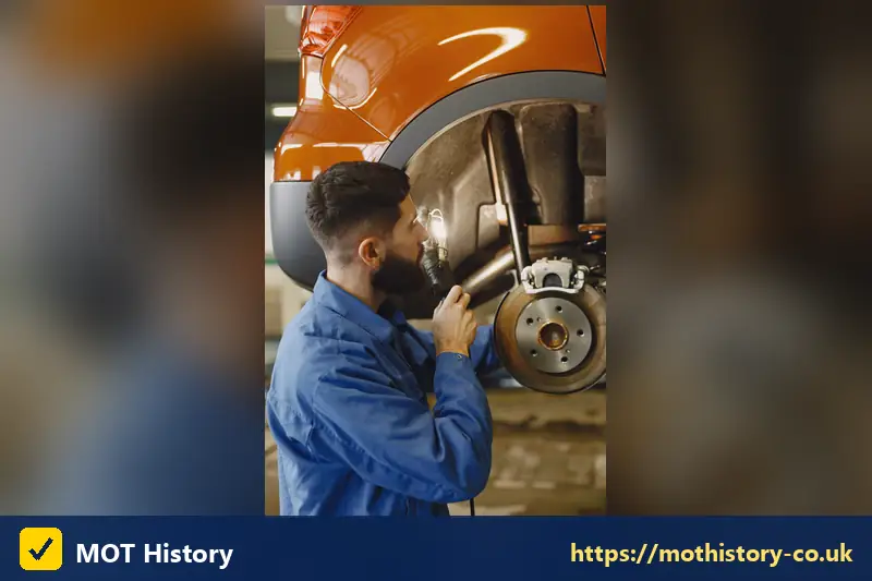 Mechanic inspecting a brake disc and suspension - car check before purchase