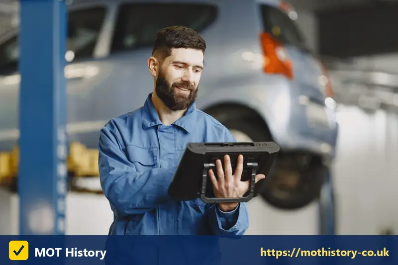 Vehicle inspector holding a tablet in a garage - car finance check review