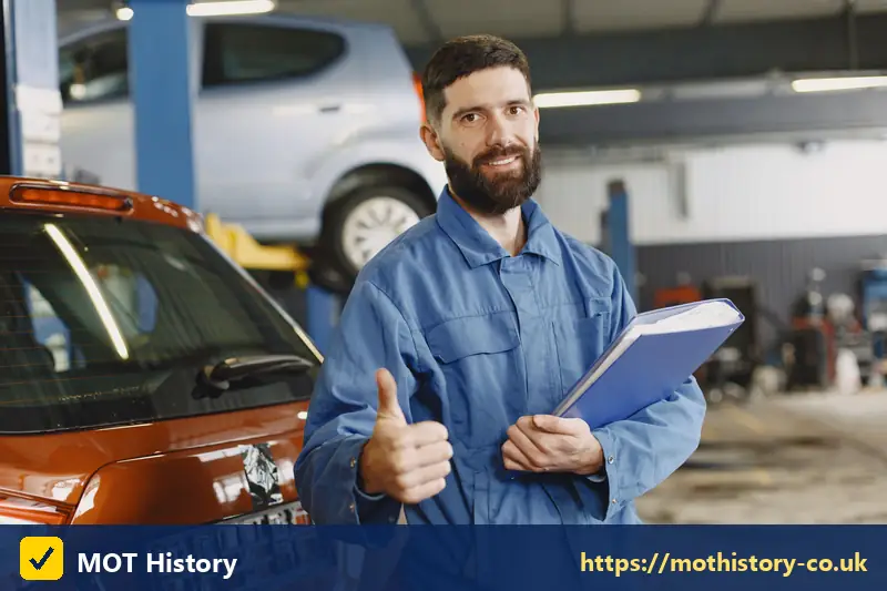 Smiling mechanic holding a folder beside a car - car spec check by reg