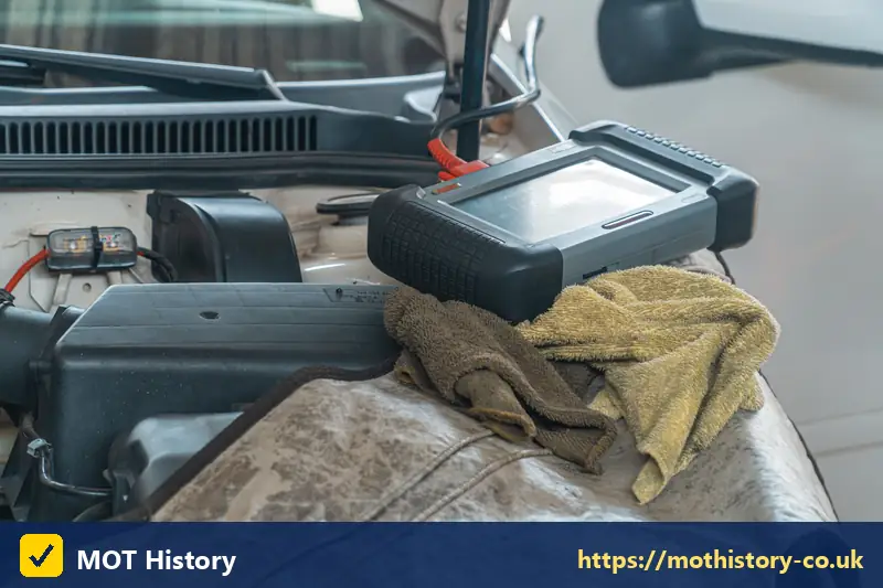 Diagnostic tablet resting on a car engine - check a car by text