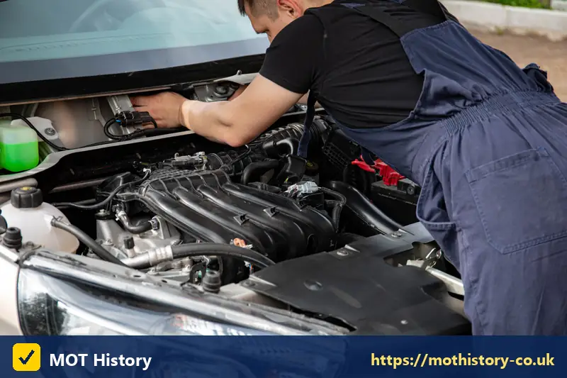 Mechanic checking engine hoses and fluid reservoirs - how long is mot