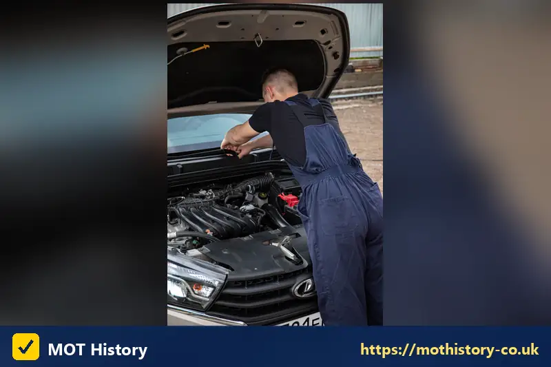 Mechanic inspecting the engine of a silver car - instant car reg valuation
