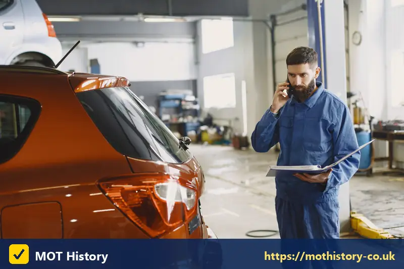 Mechanic with a clipboard on the phone in a garage - last v5 issued