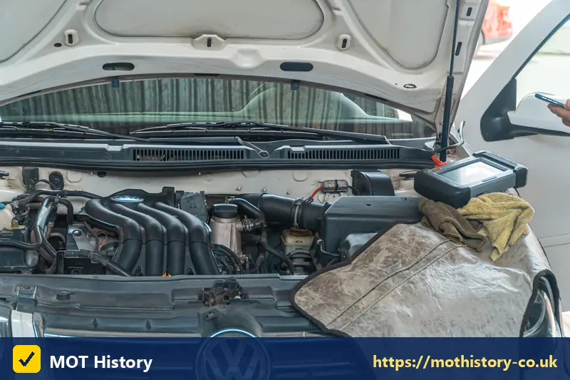 Diagnostic tablet on the engine of a white car - log on mot test