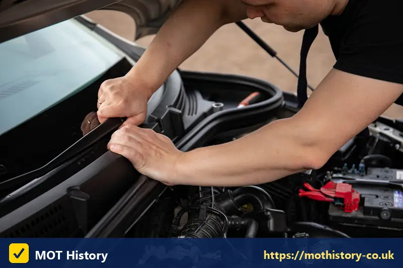 Mechanic checking under the bonnet of a car - mobile mot