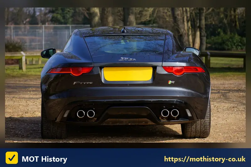 Rear of a dark coupe with a yellow number plate - spare reg plate