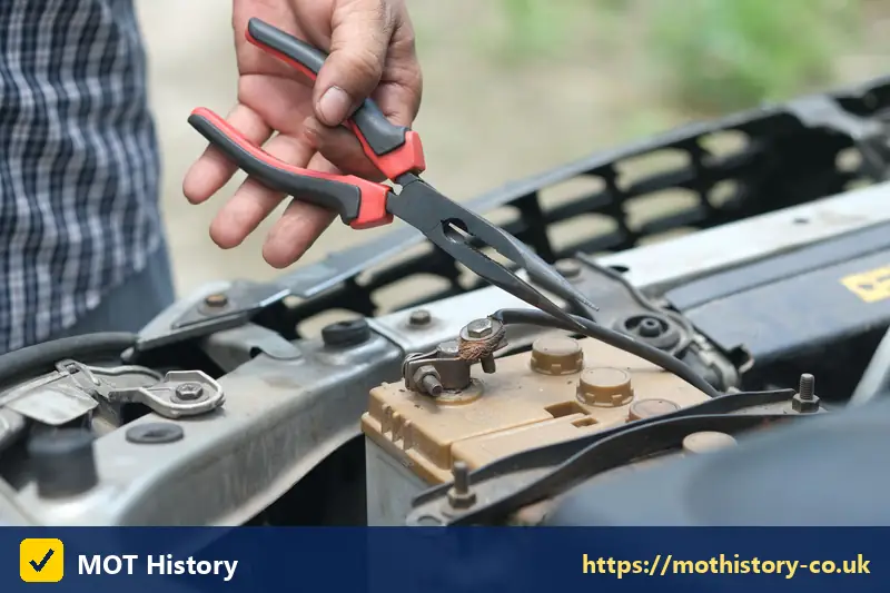 Pliers on a car battery terminal - used car checklist