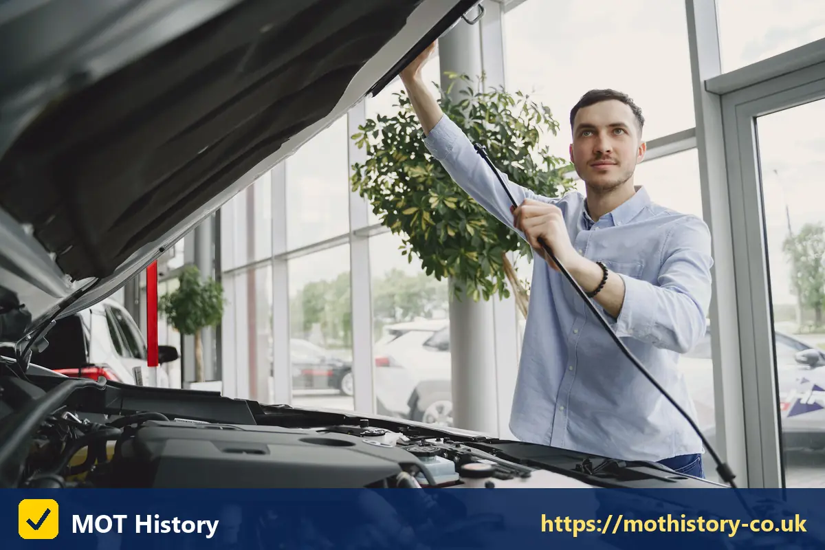 Man checking under the bonnet of a car in a showroom - car finance eligibility checker