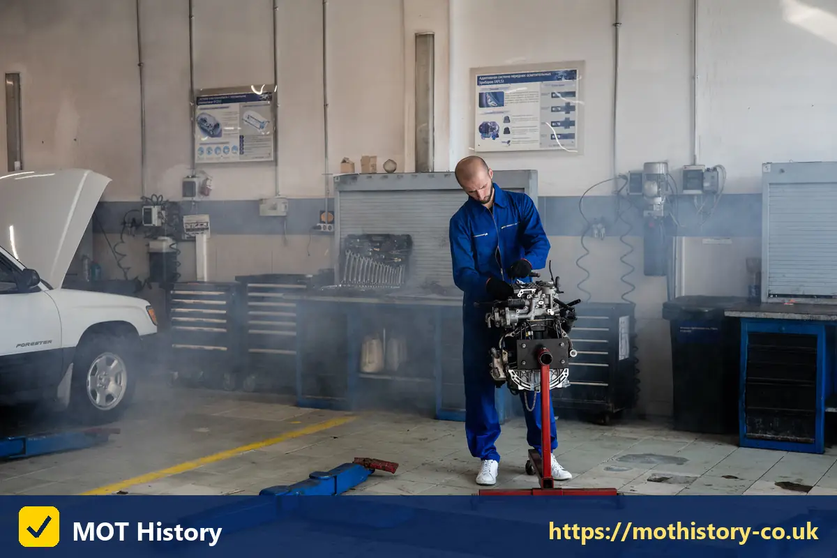 Mechanic holding an engine in a busy workshop - car service car