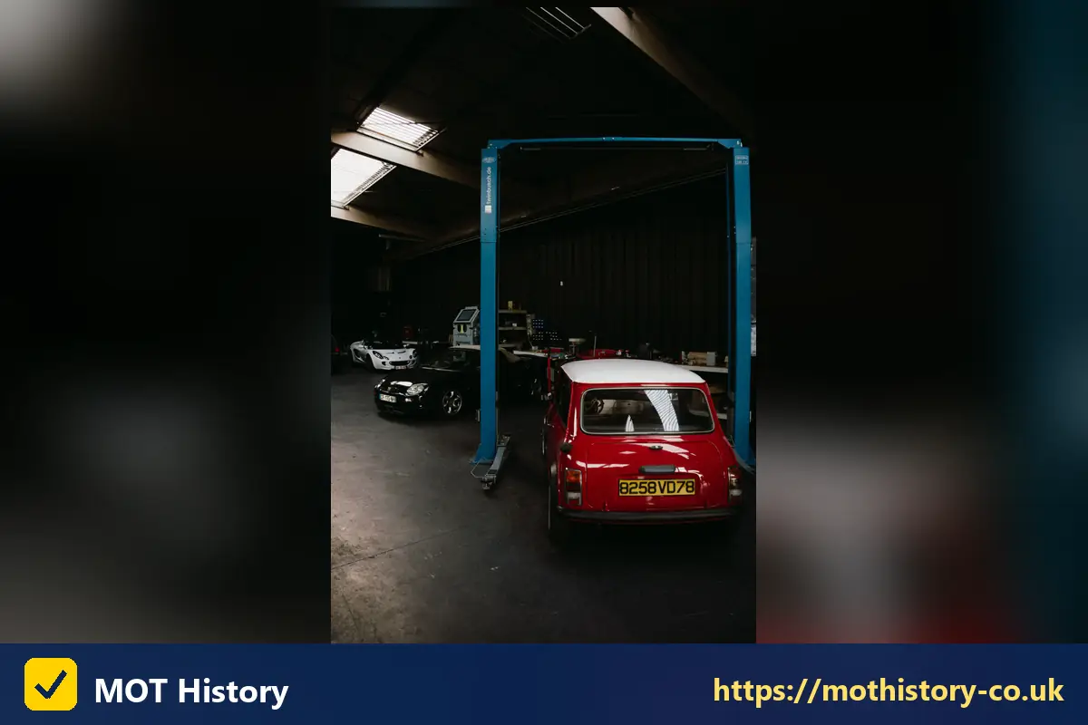 Red classic Mini on a garage lift - vehicle inspection check